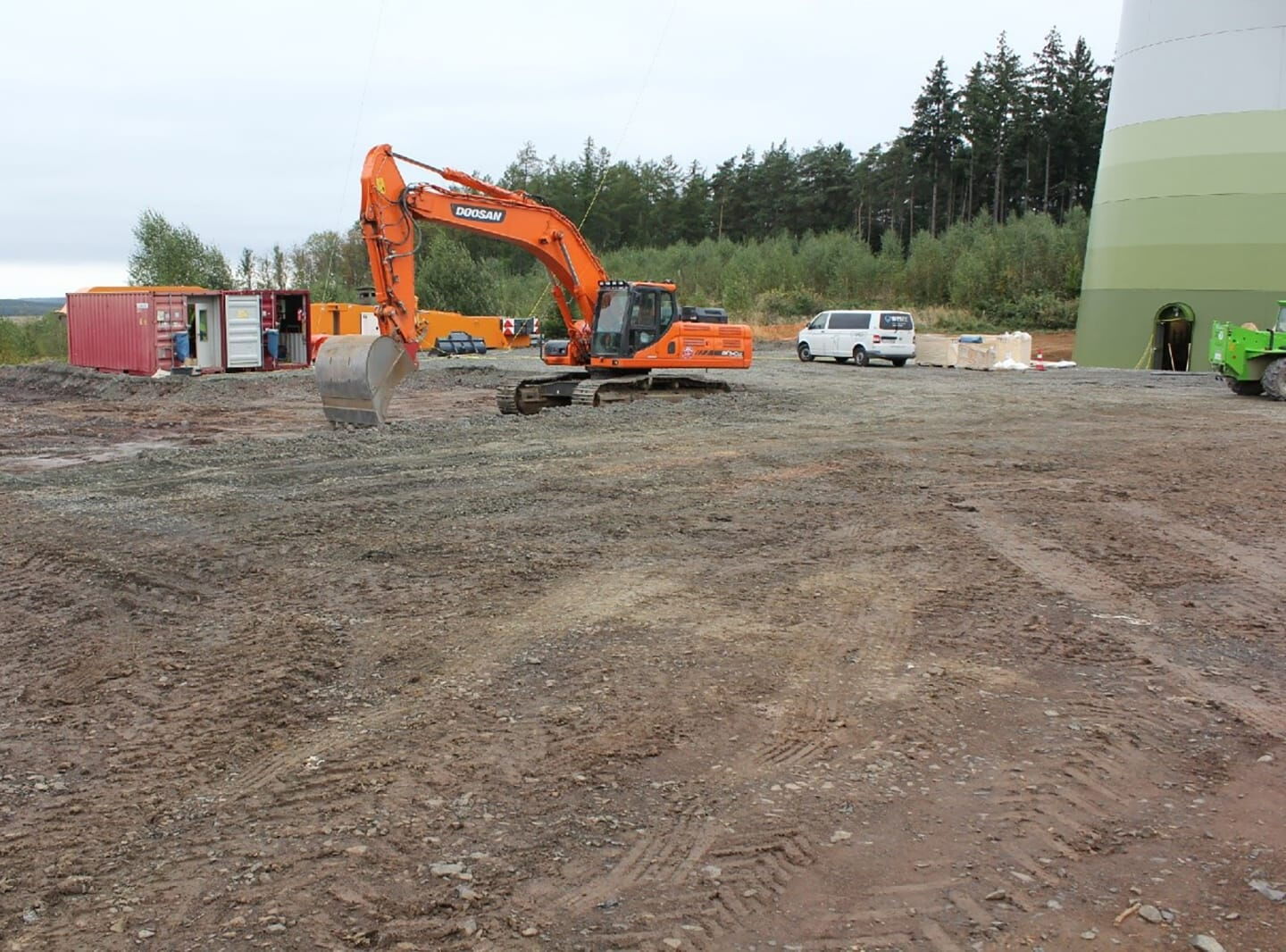 EIn Bagger steht auf einer Baustelle am Windrad